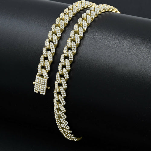 Gold chain bracelet with diamond-like stones on a black background