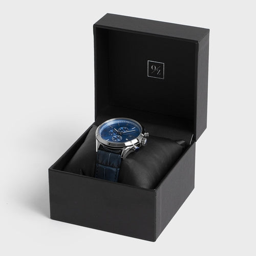 Watch with blue strap in a black box on a light gray background
