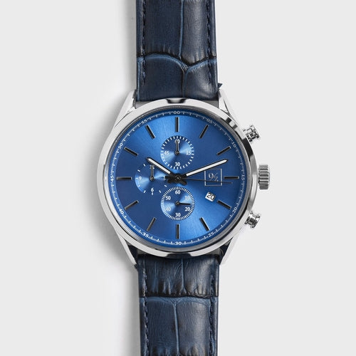 Blue watch with a blue face and blue leather strap on a light gray background