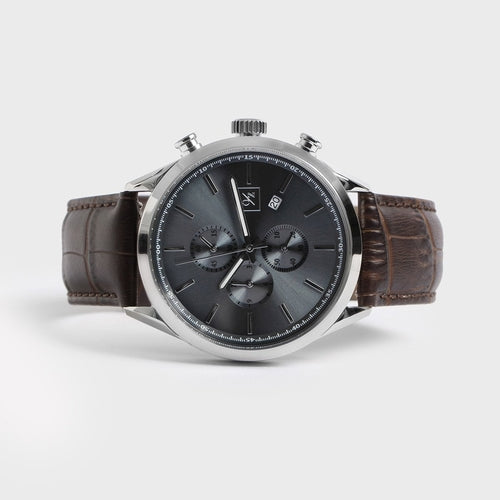 Wristwatch with brown leather strap and black dial on a white background