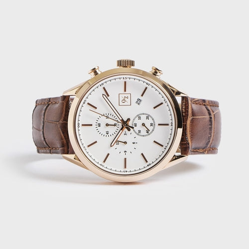Luxury watch with brown leather strap and rose gold case on a white background
